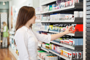 woman at pharmacy looking at over the counter medication